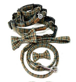 A set of dog accessories including a check tweed collar, lead, and bow tie arranged neatly on a white background.