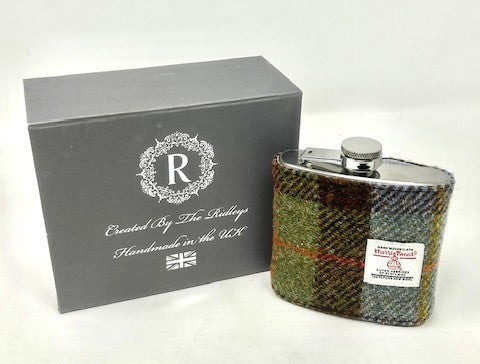 A 6oz hip flask wrapped in Harris Tweed with a stainless steel base visible, presented next to its gift box on a plain white background